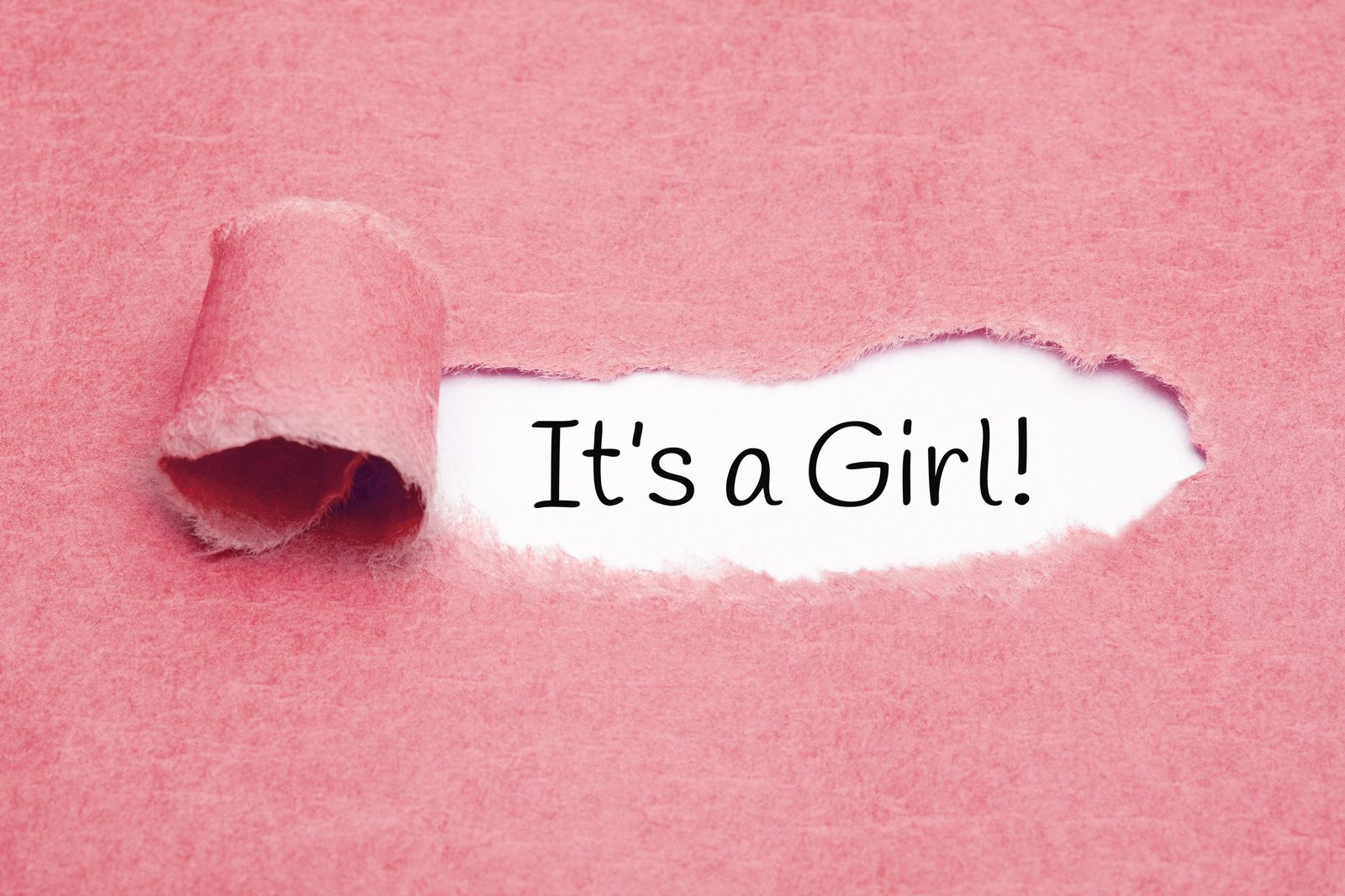 Torn pink paper opening to reveal the words It's a Girl!